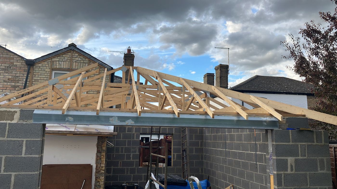 Extension under construction with roof trusses on a steel beam