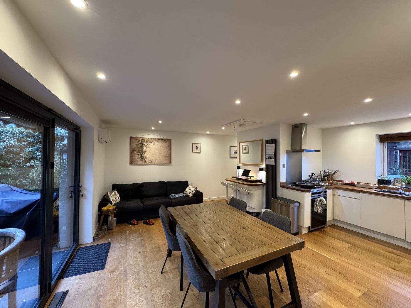 Finished open-plan kitchen, dining and living area with wooden flooring and sliding doors