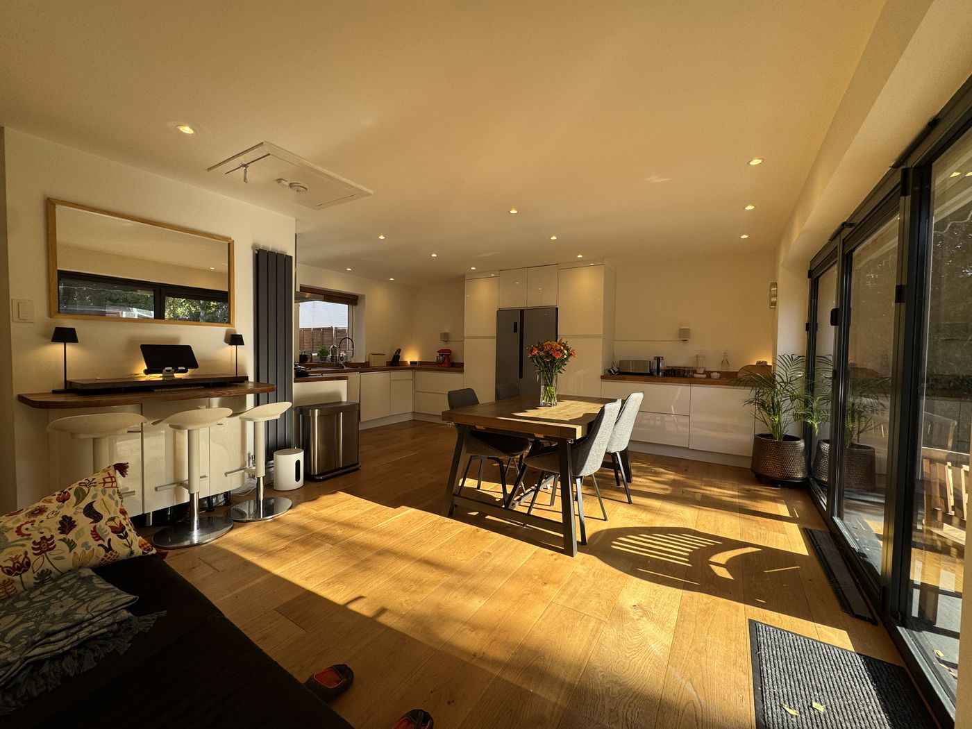 Sunlit open-plan kitchen and dining area with oak floor and sliding doors